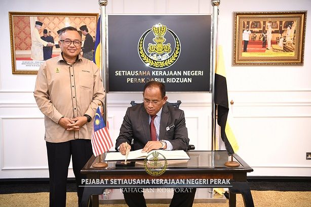 YBhg. Dato’ Haji Mohd Zakuan bin Haji Zakaria menandatangani buku pelawat sempena kunjungan hormatnya ke atas YB SUK